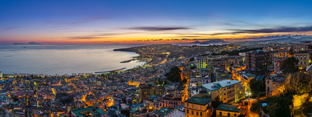 Naples, Italy. View of the city from Castel Sant'Elmo, with the Northern side of the Gulf of Naples at sunset. City lights at dusk. Banner Header image.