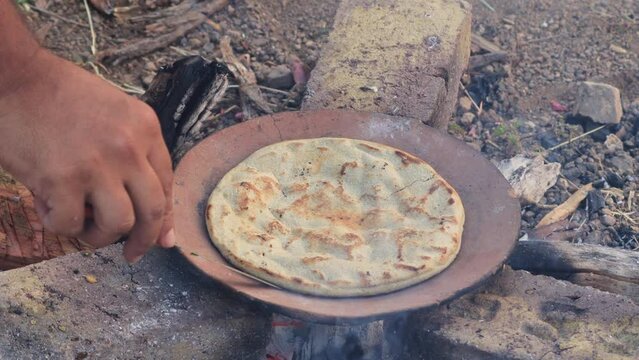 Gujarati traditional sorghum ki roti or pearl millet flat bread. lunch which are bajre ki roti. Jowar Roti or Indian bread, making process on Rural kitchen using bio wood fuel for cooking