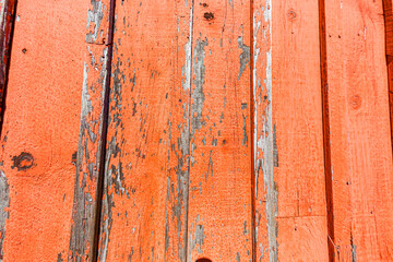 Rough, wooden background of orange, peeling boards