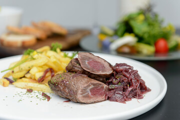 レストランのテーブルに並んだ肉料理とサラダ