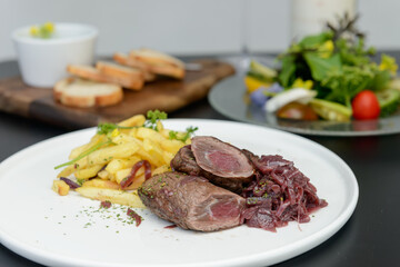 レストランのテーブルに並んだ肉料理とサラダ