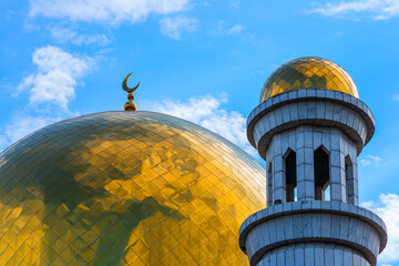 Golden dome with a crescent of the Central Mosque of the Kazakh city of Almaty against the sky
