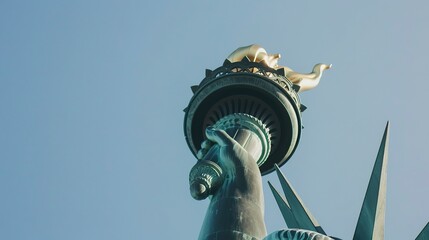 Close-up of the Statue of Liberty's torch, oxidized copper detail, clear blue sky.