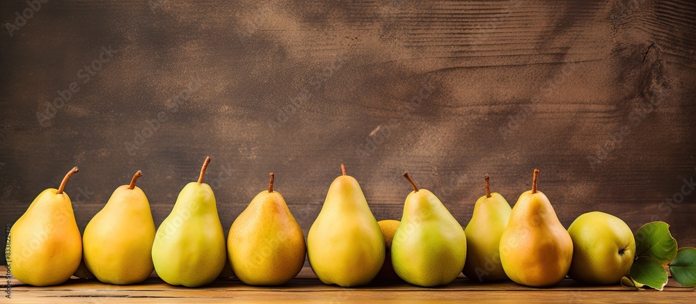 Poster fresh pears arranged on a vintage wooden table with space for text or graphics in the background; id
