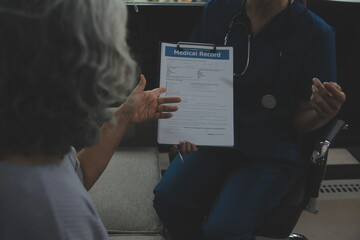 Female caregiver doing regular check-up of senior woman in her home.