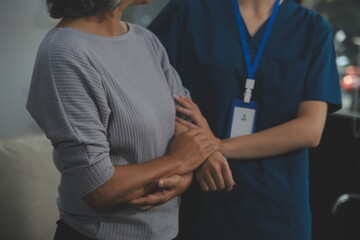 Female caregiver doing regular check-up of senior woman in her home.