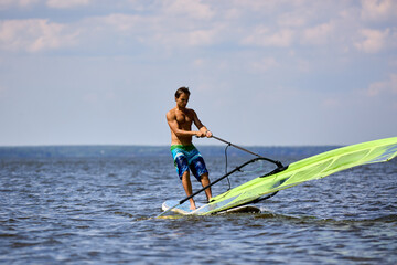 Windsurfer raise the sail of a sailboard