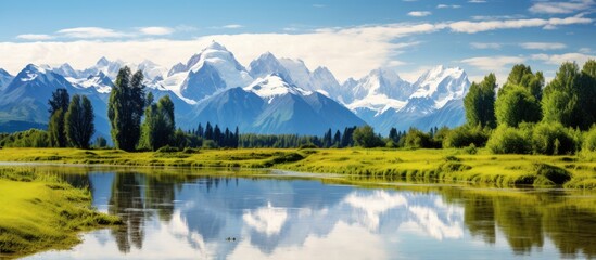 Fototapeta premium Scenic lake surrounded by snowy peaks, lush greenery, clear skies, fluffy clouds, and ample copy space image.