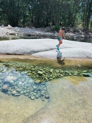 Boy walking next to a transparent river