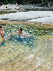 mother and child playing in to the water
