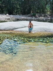Boy walking next to a transparent river