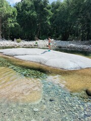 Boy walking next to a transparent river