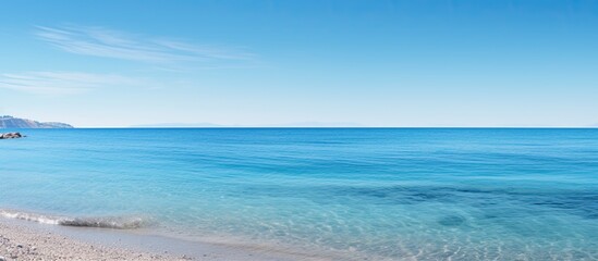 Obraz premium Tranquil seaside scene with a clear blue sky and ample copy space image.