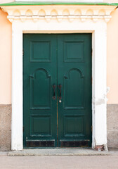 Vintage green wooden door in yellow stone wall