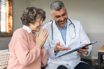 Caring man doctor talking and consult satisfied elderly female patient, doc doing regular checkup consultation to senior woman client