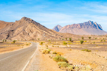 Empty road in Atlas mountains with high peaks and desert arid landscape between Agdz and Tazzarine towns, Morocco, North Africa