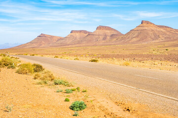 Paved road in Atlas mountains with high peaks and desert arid landscape between Agdz and Zagora towns, Morocco, North Africa