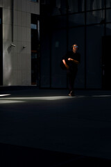 Middle-aged Caucasian man walking in an urban environment wearing black attire