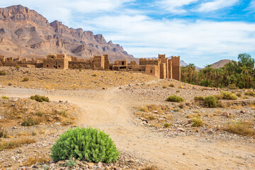 Dirt path to old ancient ruins of Tamnougalt village in desert landscape of Atlas Mountains,...