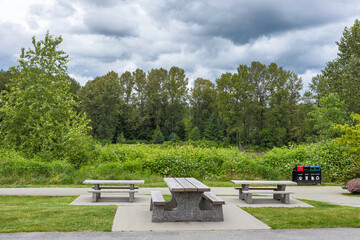 Picnic table and benches on green lawn in a park