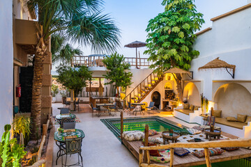 Illuminated with lights courtyard with swimming pool of traditional riad guesthouse in the evening...