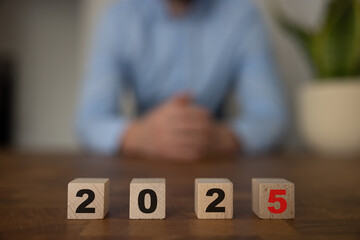 Wooden block with numbers 2025 on wooden table with white background, New Year 2025 