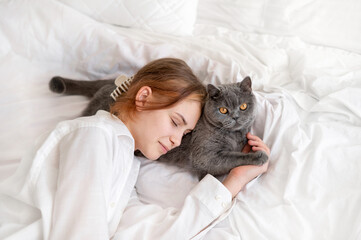 Child and pet good relations, love and friendship, girl laying on bed, sleeping together with her...