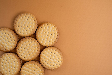 Sandwich cookies, chocolate cream filled biscuit stuck on brown yellow background. Modern cookies concept.
