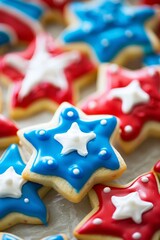 Obraz premium A close-up of patriotic-themed cookies with red, white, and blue icing and star-shaped decorations, with a blurred background for text placement.