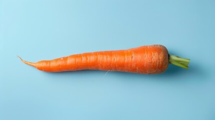 Close-up of a bright orange carrot on a light blue background, showcasing its vivid color and freshness. Ideal for themes of nutrition and healthy lifestyle