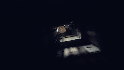 A dark tunnel of a lift shaft with a small opening at the end through which light enters. The...