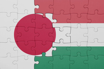 puzzle with the colourful national flag of hungary and flag of japan.