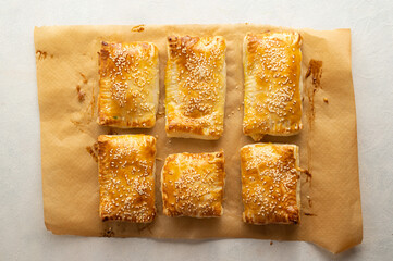 Puff pastry dough. Folded baked puff pastry pies portions, top view.
