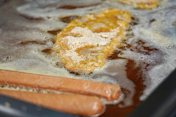 Fried schnitzel on the stove in the kitchen of a restaurant before serving the dish.