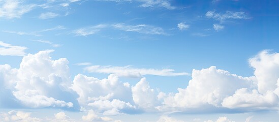 A picturesque scene showing a clear blue sky with fluffy white clouds, providing a serene copy space image.
