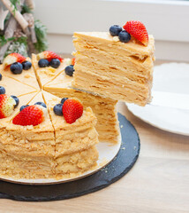 Napoleon cake decorated with fresh berries and fruits. Delicious dessert for any occasion