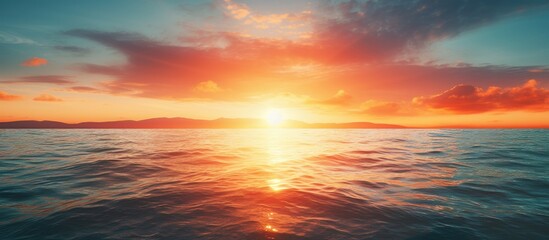 Fototapeta premium Sun setting over the ocean with copy space image.