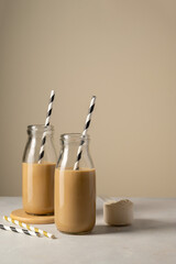 Chocolate protein drinks in glass bottles with paper straw.