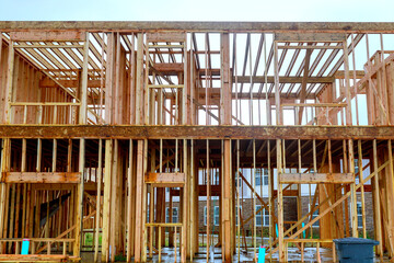 An unfinished interior of newly built house with wooden stud timber framing supports beams