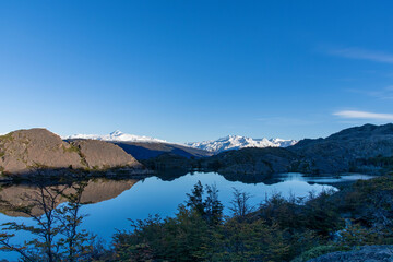 View over Lago Grey (Grey Lake) with perfect reflection of snow covered mountains of the Paine Massif in water along W-trek hiking route in Torres del Paine National Park, Patagonia, Chile