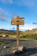 Torres del Paine National Park, Patagonia, Chile; Wooden sign on W-trek hiking route indicating sectors (Chileno, Cuernos, Frances) and outlook point for three granite towers (Mirador Base Torres)
