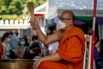 Buddhist monk welcoming tourists with a blessing