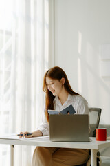 Asian business woman have the joy of talking on the phone, laptop and tablet on the office desk	