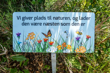 Hillerod, Denmark A sign on a lawn says in Danish: "We yield place to nature and let it be almost as it is."