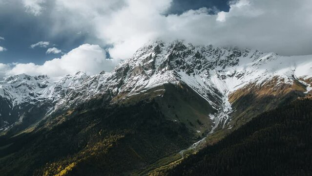 hyperlapse Mount Ushba at sunset in the clouds, timelapse view from above