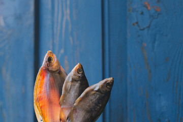 dried fish on a blue background, beer snack	