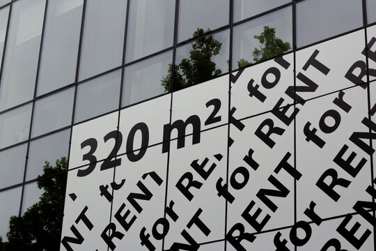 Horizontal street photo. Black text on white sticker. Pattern for Rent on glass window wall. 320 square meters. Rent of non-residential commercial premises, apartments, shops, warehouses. Number, Sale