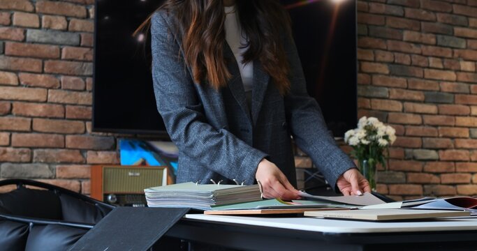 Creative team of interior designers in collaborative meeting, analyzing various material samples and color palettes. Engaged in detailed project planning, fostering innovative design solutions.