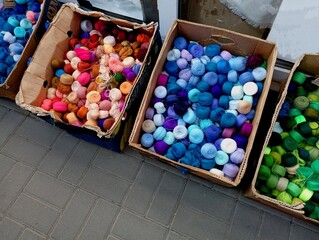 In cardboard boxes, many balls of various threads are displayed for selection and sale.