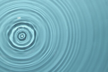 Rippled surface of clear water on light blue background, top view